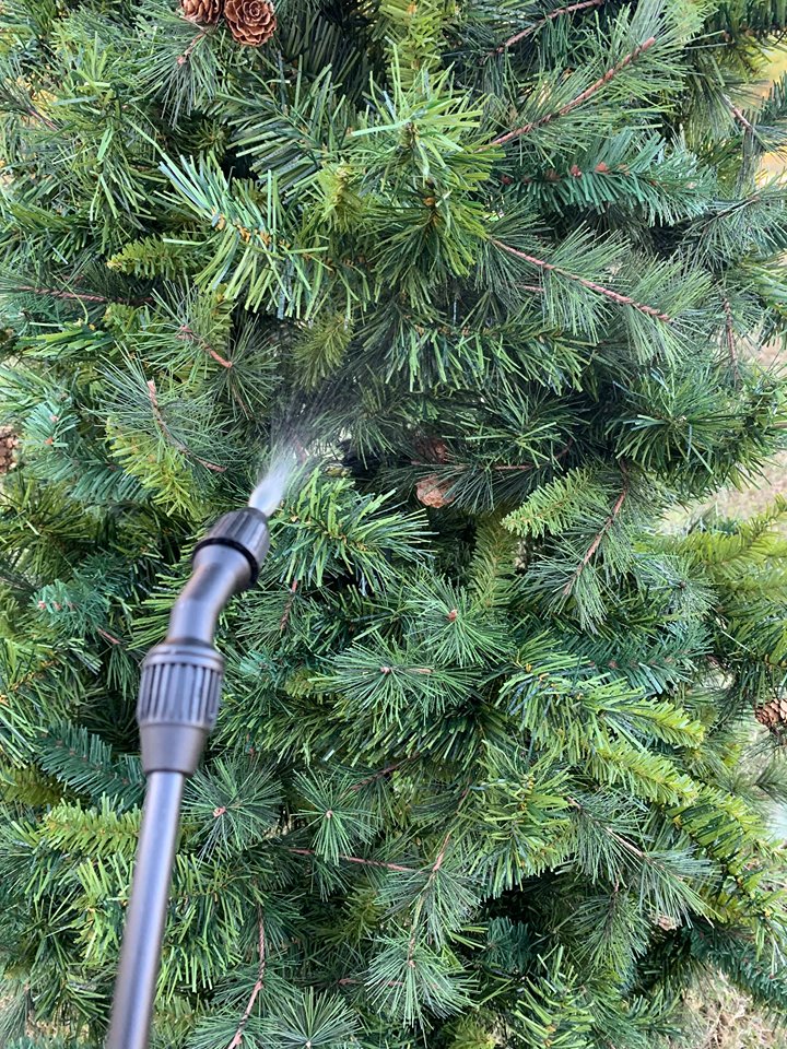 misting an artificial tree with water before applying snoflock