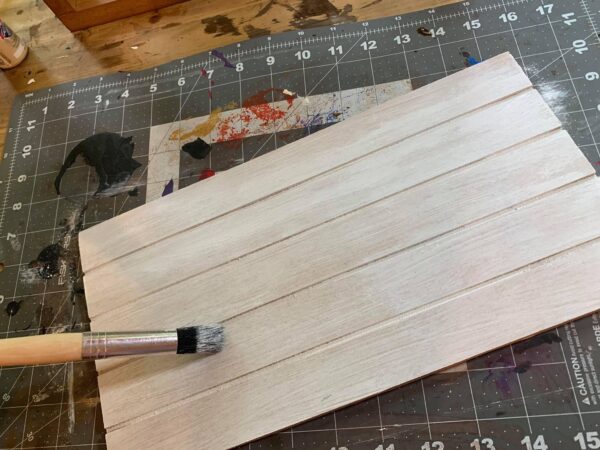 white shiplap board and paintbrush