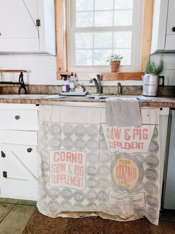 red blue and yellow feed sack used as a curtain under sink