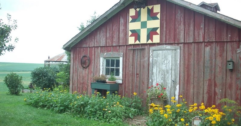 red rustic barn with colorful quilt