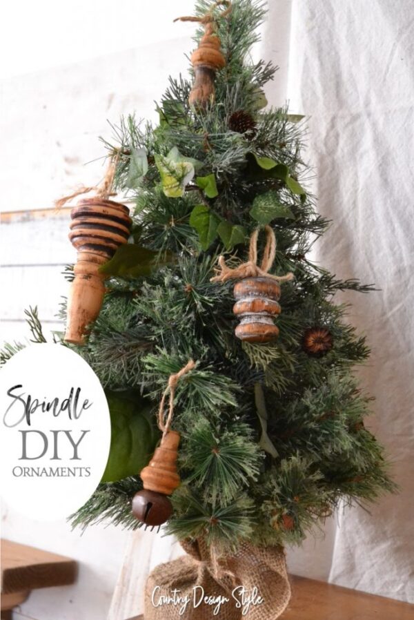 rustic spindle ornaments on a small naked Christmas tree with burlap tree skirt