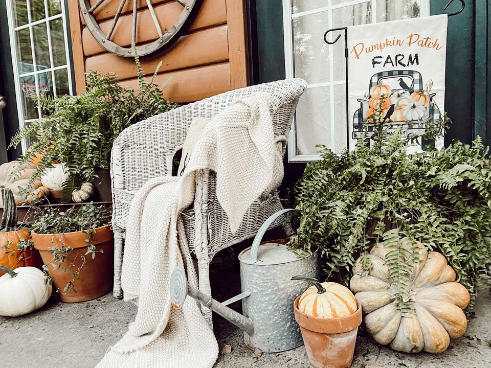ferns and pumpkins with old white wicker chair